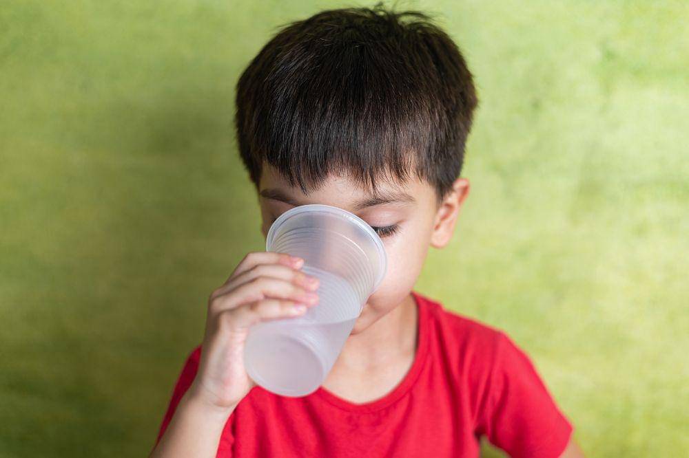 boy with red tshirt drinking water