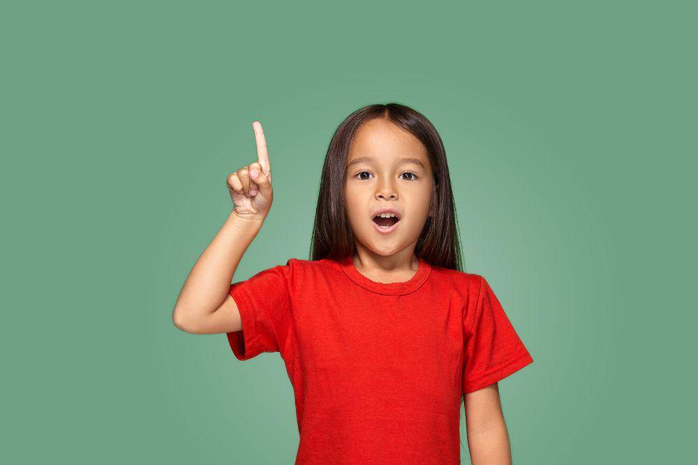 Little girl in red t-shirt with finger up