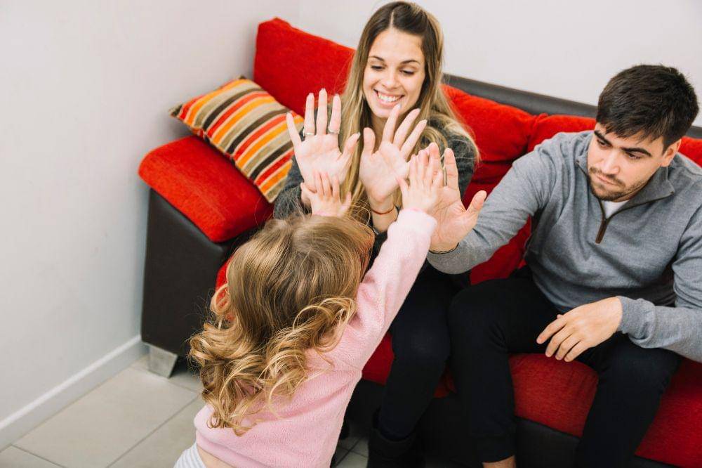 Parents giving high five to their daughter