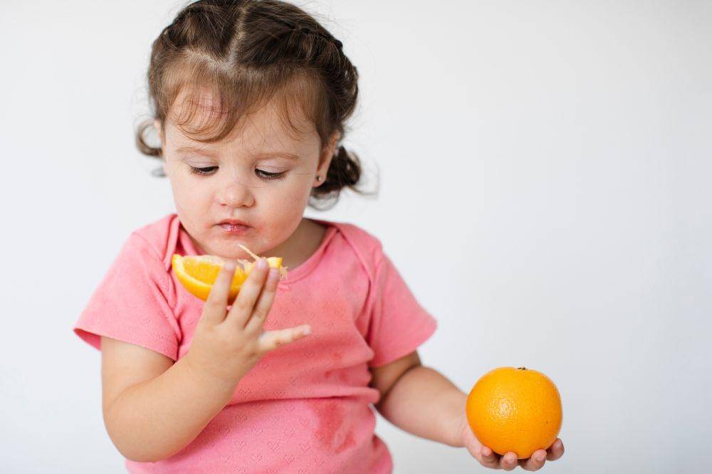 little girl looking at her oranges