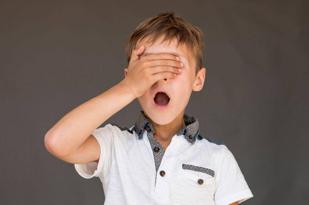Shocked boy covering his eyes