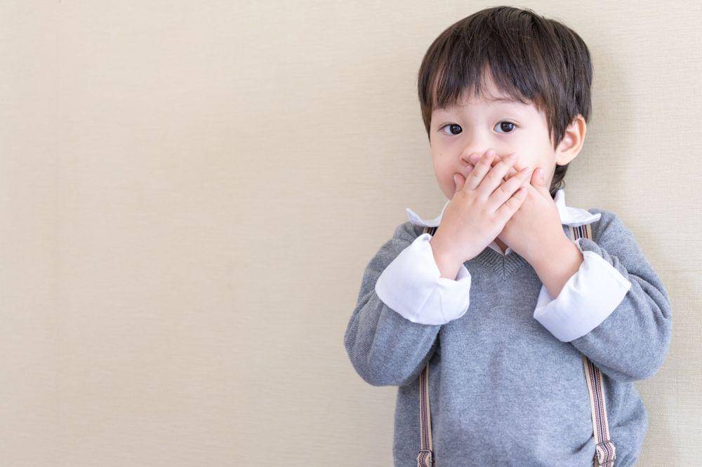 asian boy standing and closed his mouth