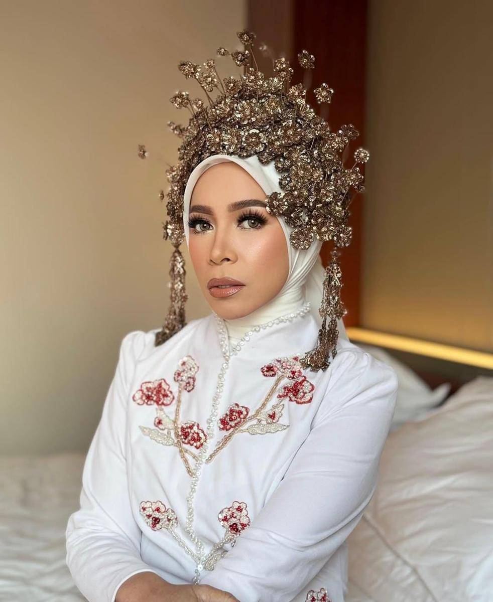 Melly Goeslaw mengenakan kebaya putih dan headpiece mewah