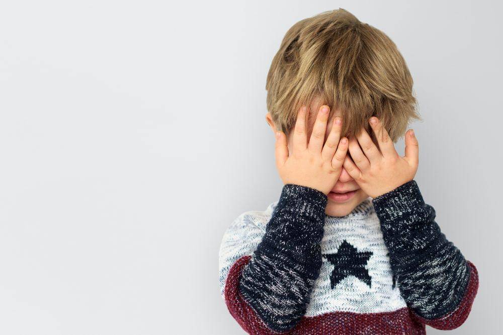 Little boy hands hidden face