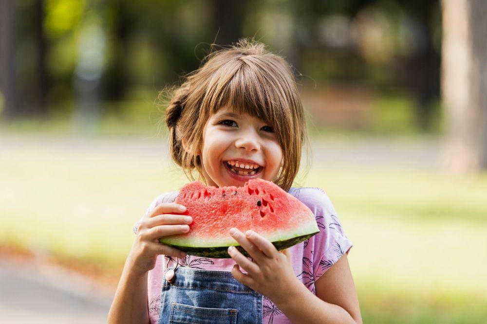 Smiley girl enjoying watermelon
