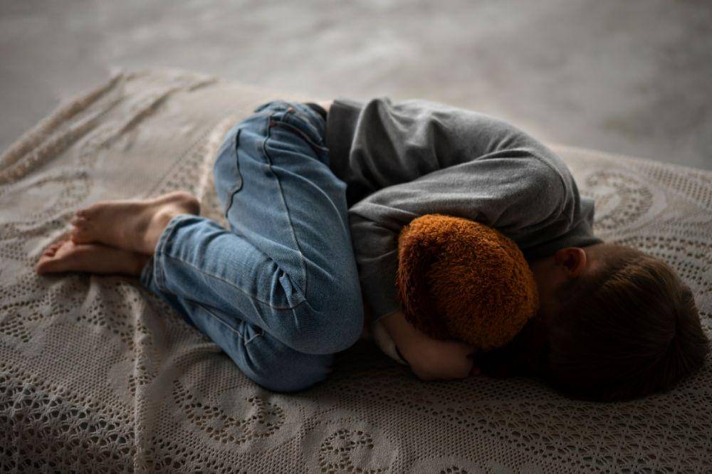 non explicit image of child abuse hugging a doll