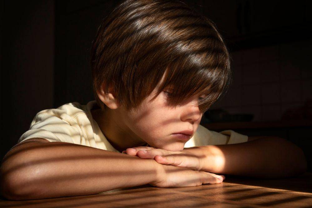 sad boy sitting indoors