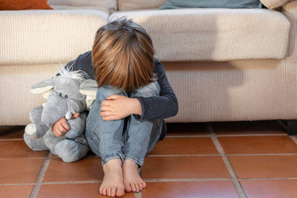 Little boy outdoors upset holding his toy