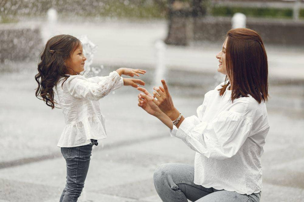 mother with gaughter playing with water