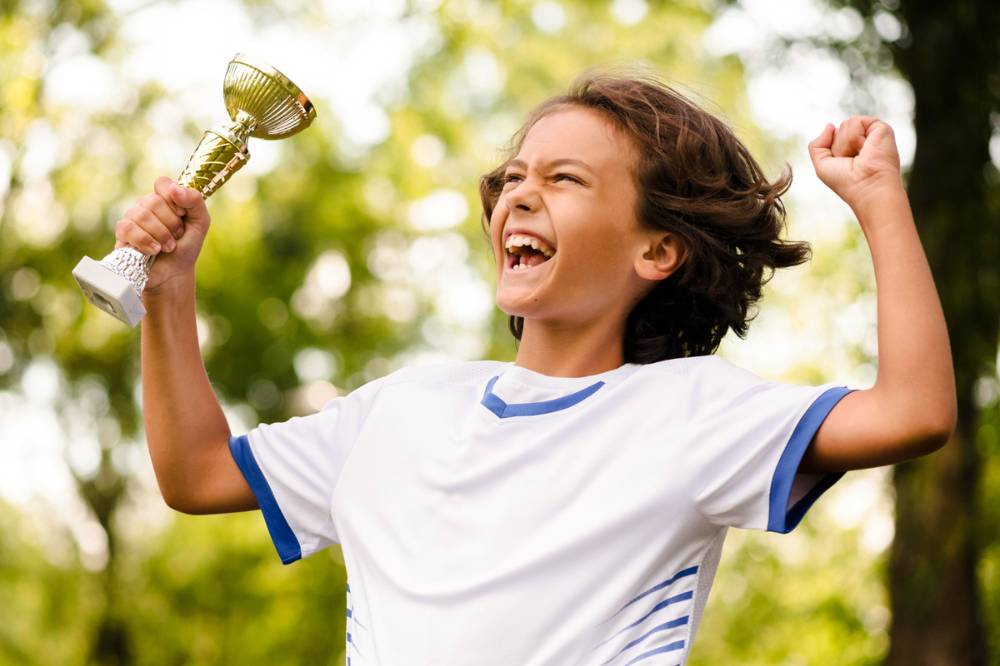 Anak memegang piala