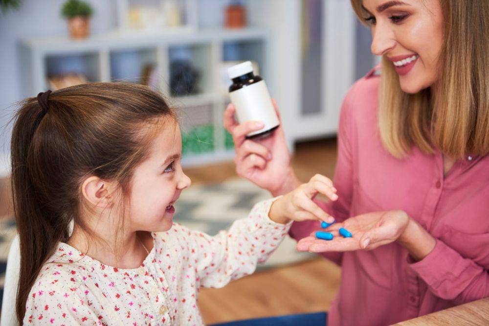 Mom giving her little daughter the medicine