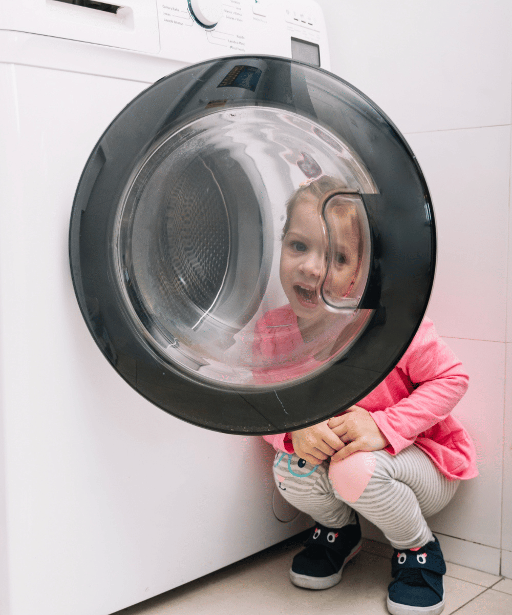 Anak bermain dekat mesin cuci