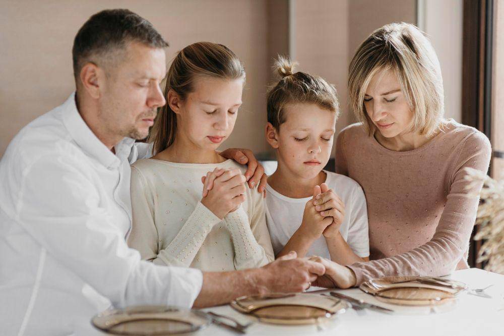 Family praying together before eating