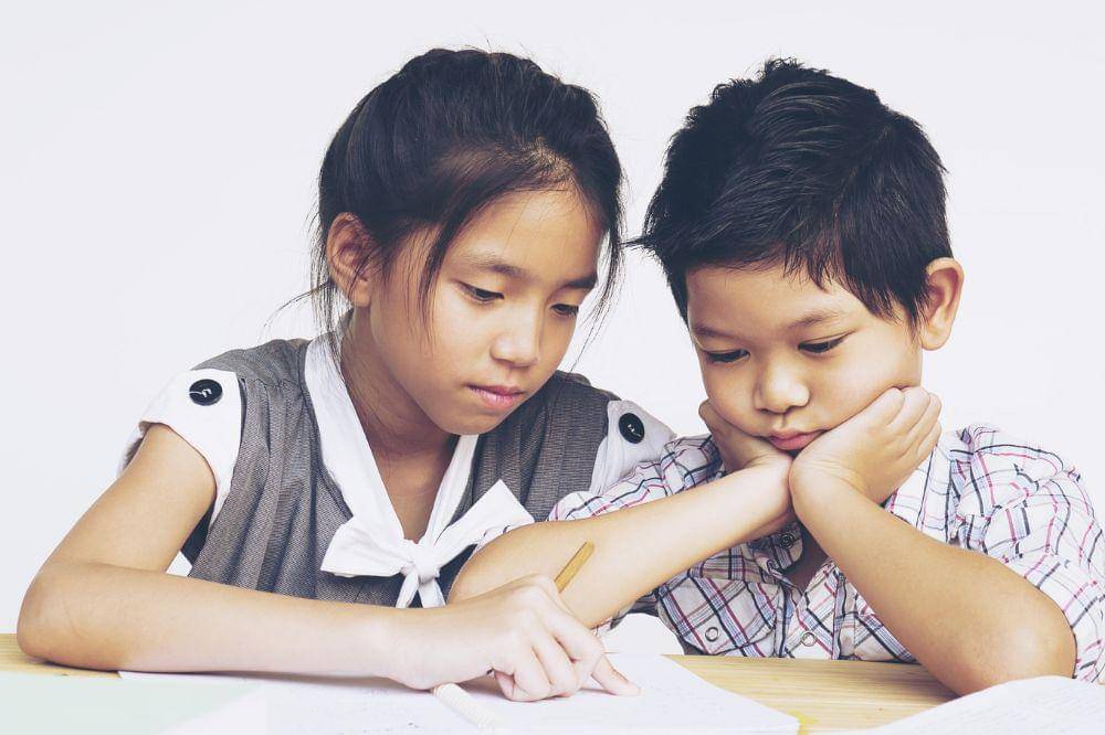 Sister teach her brother to do homework