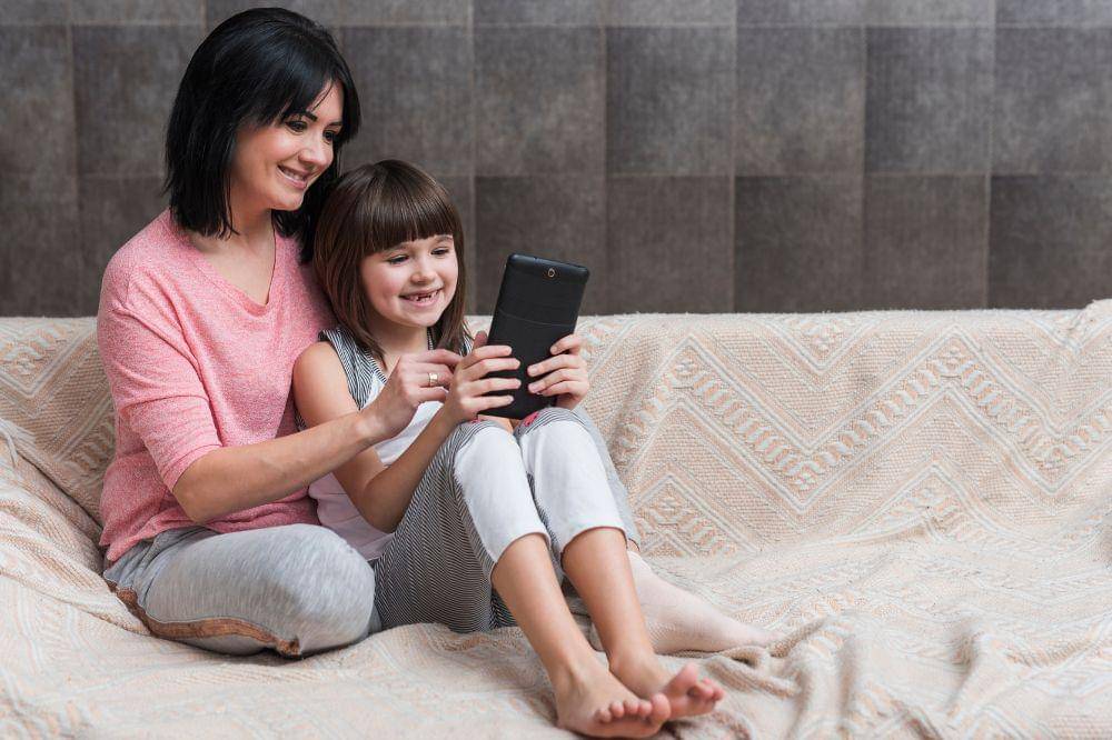 Mother and little daughter using tablet