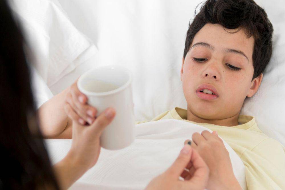 sick boy taking pill