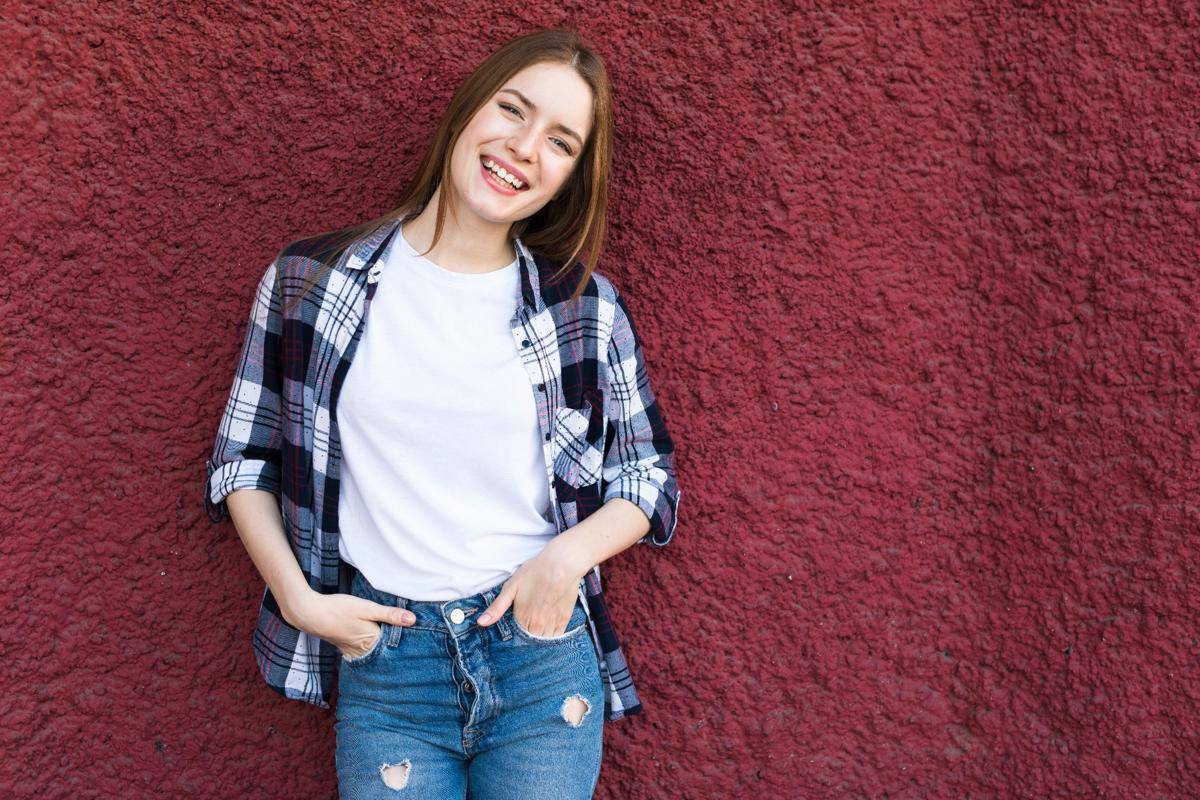 fashionable-happy-woman-leaning-red-textured-wall.jpg
