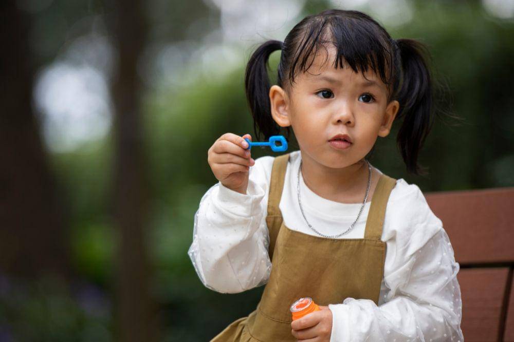 Little girl sitting on bench