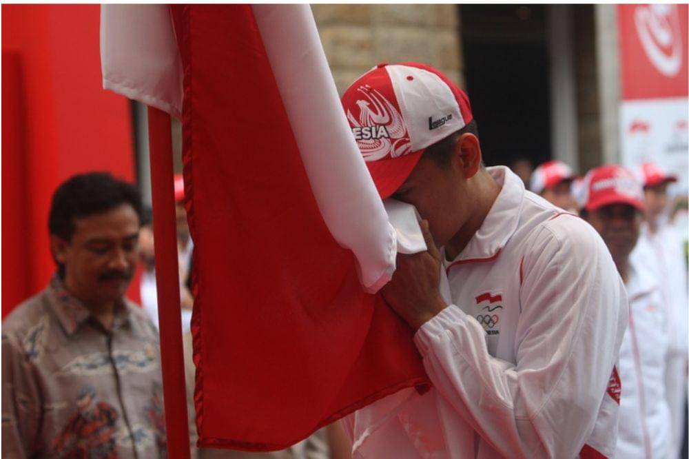 Anak Laki-laki Sedang Mencium Bendera Indonesia