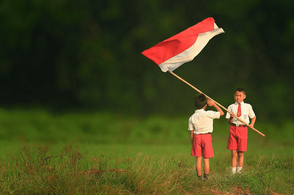 anak sekolah memegang bendera