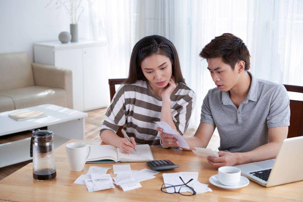Man and woman calculating domestic budget at home