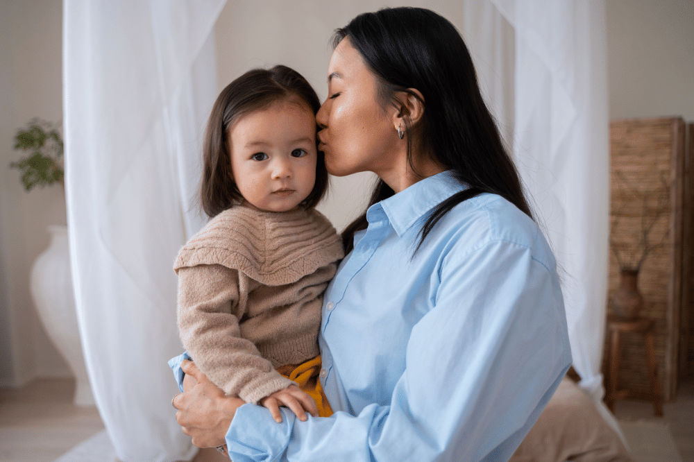Mama sedang mencium kening anak perempuannya