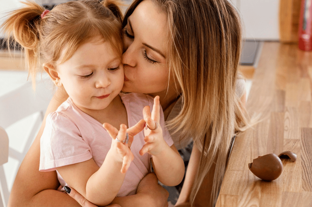 Mama mencium anak perempuan dengan kasih sayang