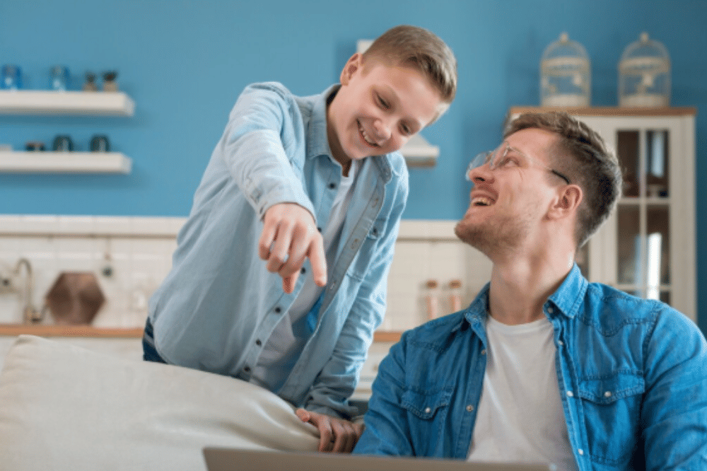 Papa berbincang dengan anak untuk mencari solusi bersama menggunakan laptop