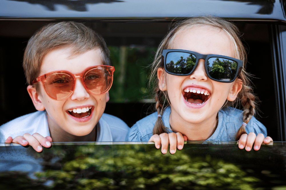 dua anak tertawa dari dalam mobil