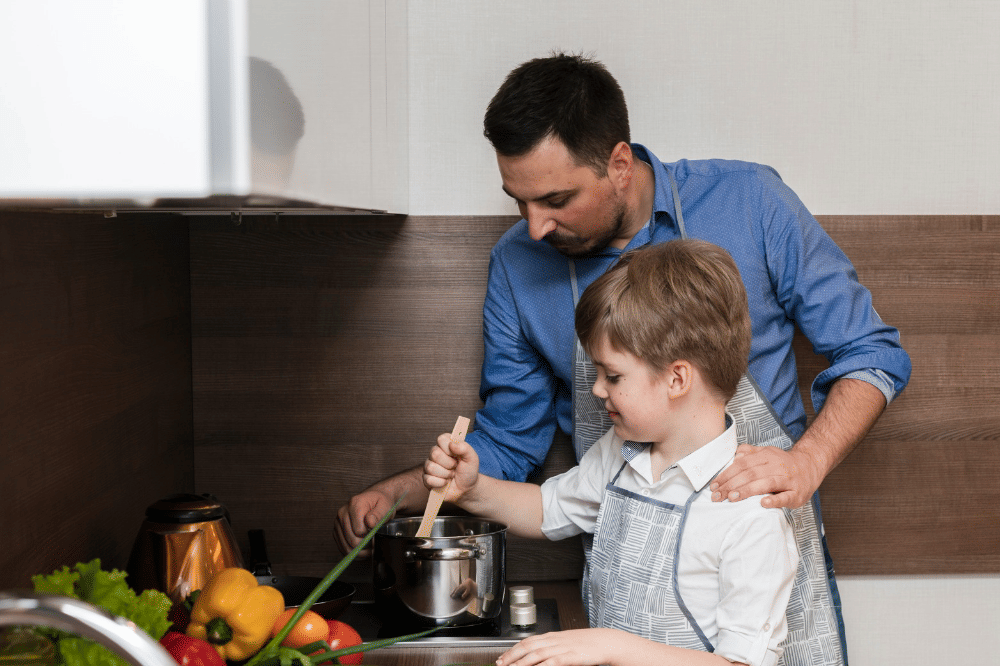 Papa dan anak laki-laki sedang memasak bersama di rumah