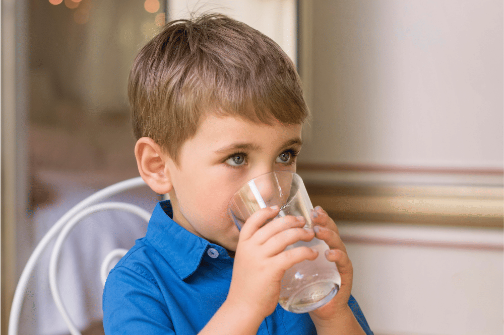 Anak laki-laki sedang minum air