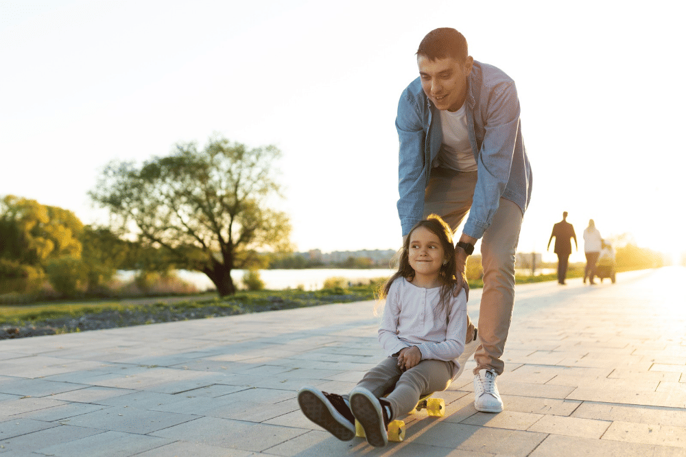 Papa dan anak sedang bermain di taman pada sore hari