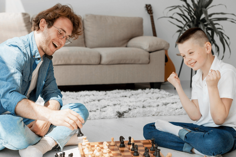 Papa dan anak sedang bermain catur