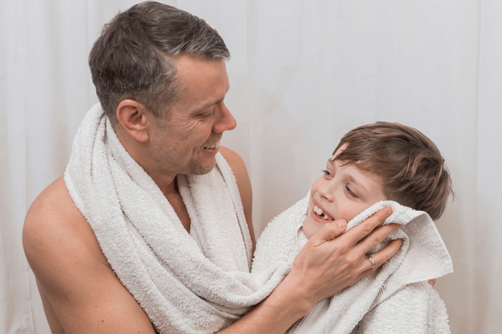Papa sedang mengeringkan tubuh anak dengan handuk setelah mandi