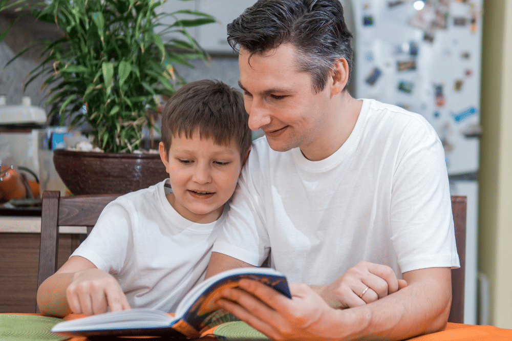 Papa dan anak sedang membaca buku bersama