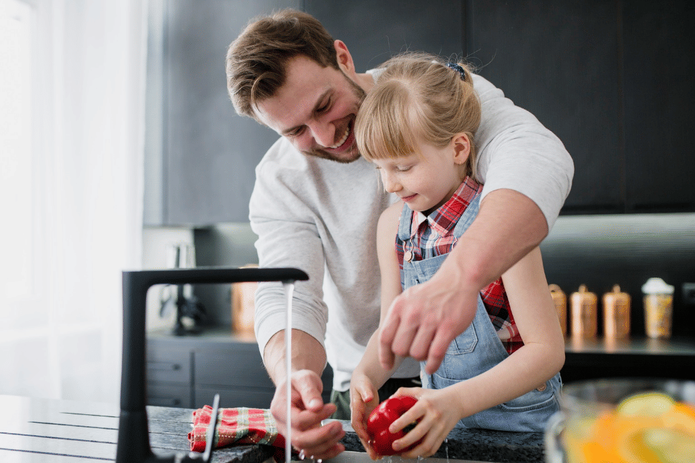 Papa dan anak sedang mencuci sayur