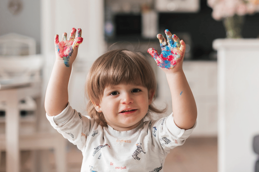 Anak sedang mengeluarkan imajinasinya dengan bermain cat warna