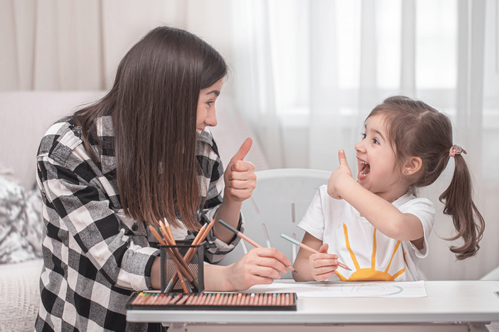 Mama mengobrol sambil mengajari anak perempuan dengan menggambar