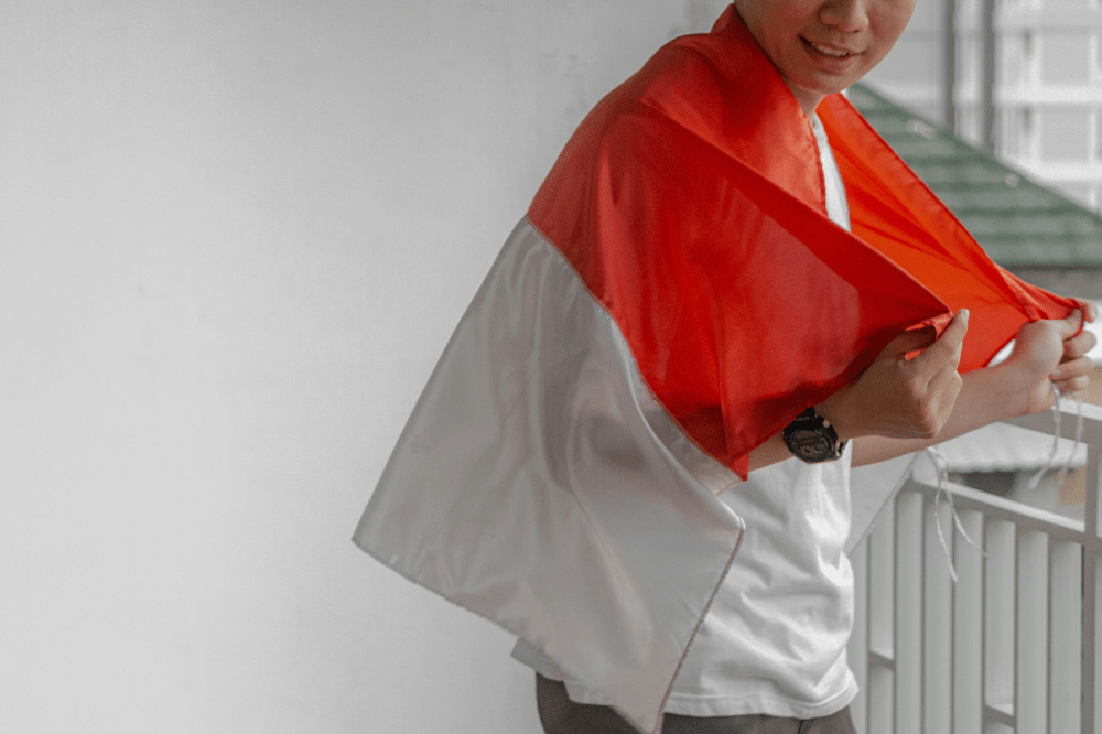 Seorang laki-laki memegang bendera merah putih