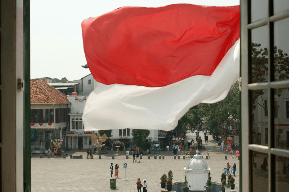 Bendera merah putih berkibar terkena angin yang terlihat dari jendela