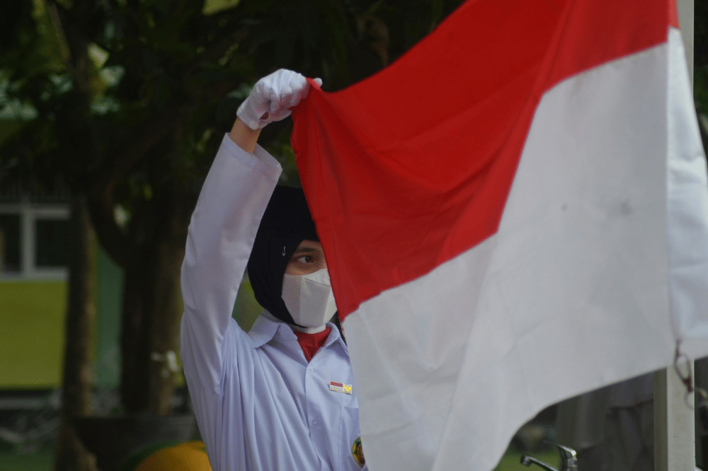 Seorang siswa memegang bendera merah putih