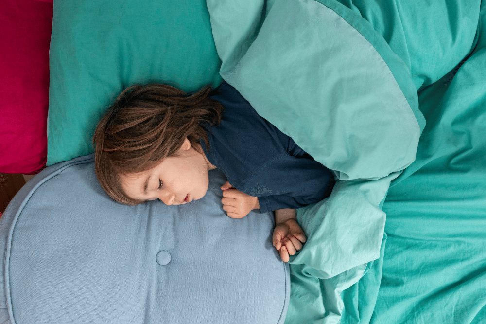 Anak sedang tidur di atas kasur