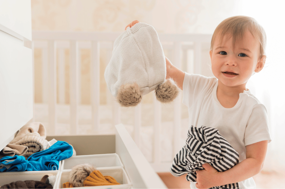 Anak laki-laki sedang memilih dan mengambil pakaiannya sendiri