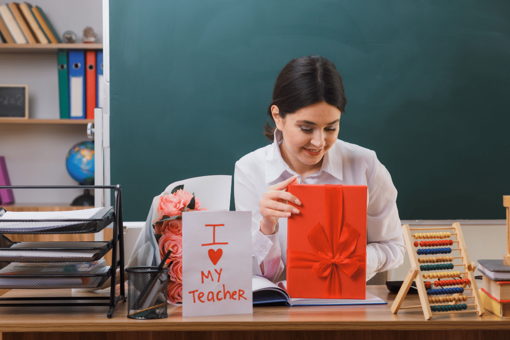 Seorang guru sedang membuka hadiah dan surat pada Hari Guru