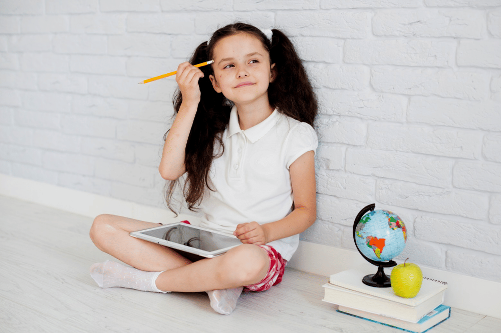 Anak perempuan terlihat berpikir saat belajar menggunakan tablet