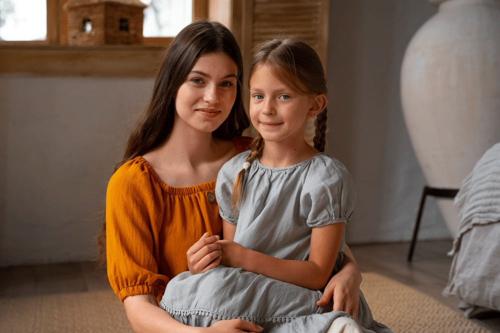 Mama sedang memangku anak perempuandan tersenyum