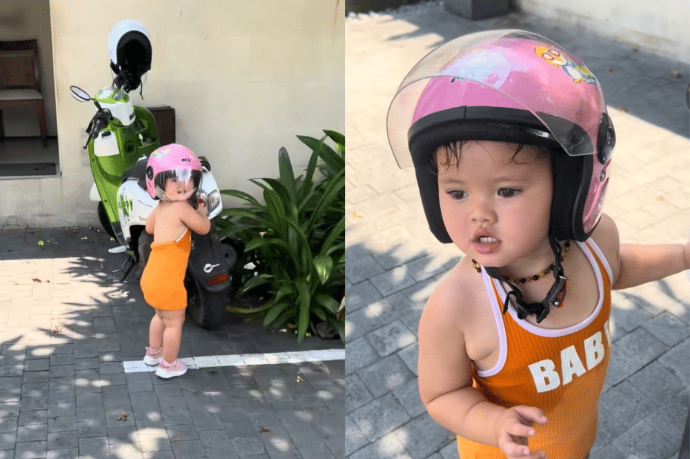 Briella memakai mini dress coklat-oranye dengan helm pink