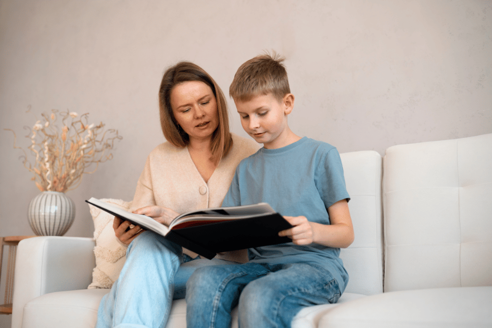 Mama an ank laki-laki sedang melihat album foto bersama