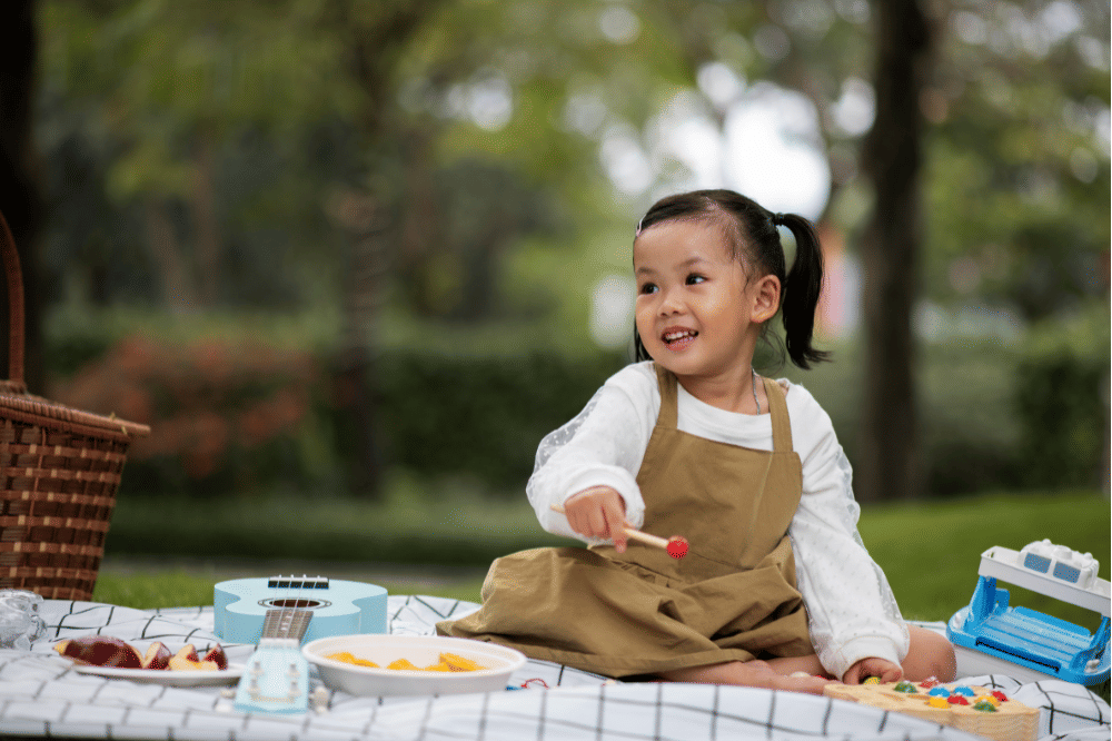 Anak perempuan terlihat senang saat sedang piknik di taman