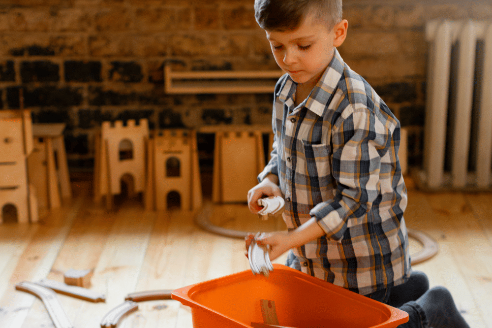 anak yang sudah mandiri membereskan mainannya